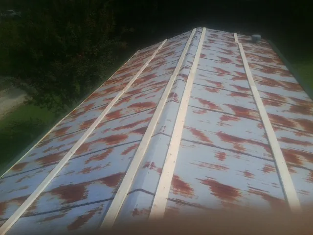 Rusted metal roof panels with new wood purlins before replacement — Storm Damage Roof Repair in Hope Mills by Roofing Brothers