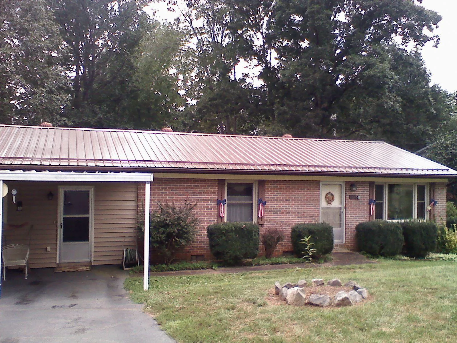 Bronze metal roof and carport on a brick ranch home — Roof Repair work by our crew in Hope Mills