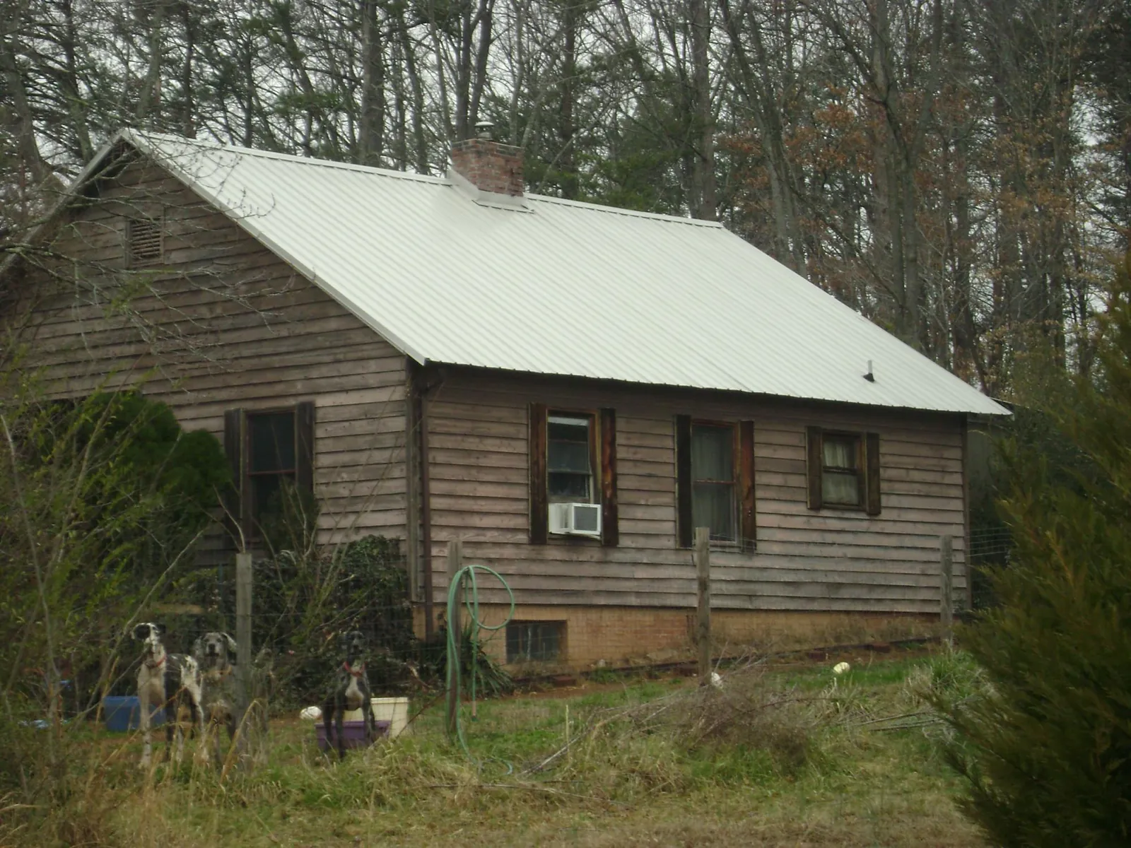 White metal roof on an old wood sided farmhouse, from a Metal Roof Installation job in Hope Mills